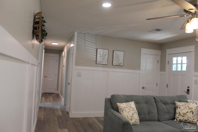 30 Woodham Ave, Ft Walton Beach, FL 32547 - living room with a decorative wall, a ceiling fan, a wainscoted wall, dark wood-type flooring, and a textured ceiling