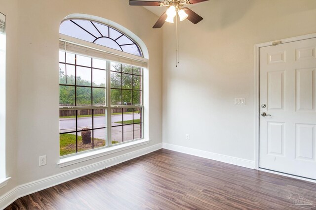 unfurnished room with ceiling fan, baseboards, and dark wood-style floors