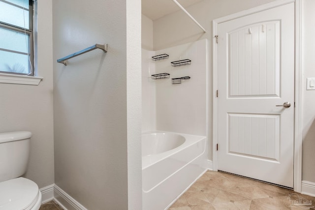 full bath featuring toilet, baseboards, and  shower combination