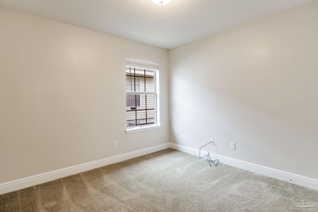 carpeted spare room with baseboards and a textured ceiling