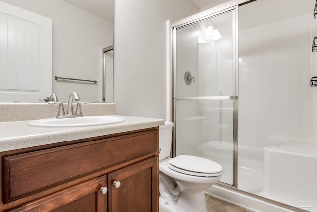 bathroom featuring a shower stall, tile patterned floors, vanity, and toilet