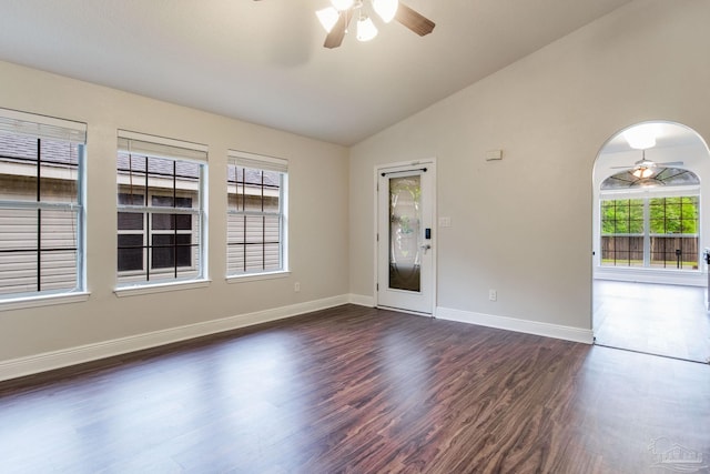 unfurnished room with ceiling fan, plenty of natural light, vaulted ceiling, and dark wood finished floors