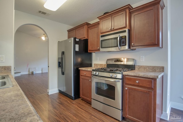 kitchen featuring dark wood-type flooring, light countertops, and stainless steel appliances