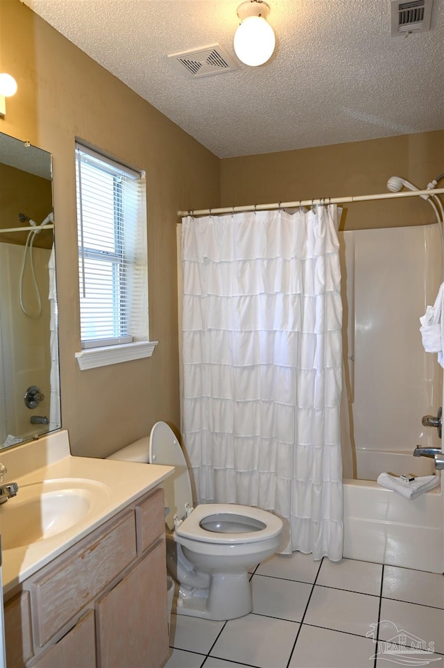 full bathroom featuring shower / bath combination with curtain, a textured ceiling, toilet, vanity, and tile patterned floors