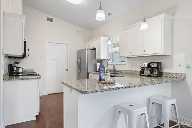 kitchen with white cabinets, light stone countertops, lofted ceiling, kitchen peninsula, and pendant lighting