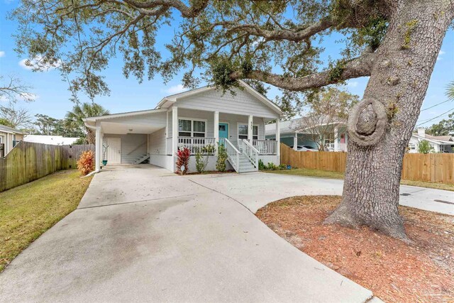 view of front of home featuring a porch, a carport, and a front lawn