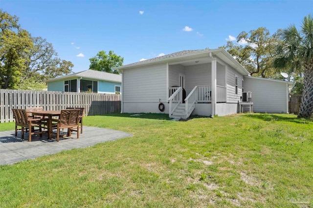 back of property with a patio area and a yard