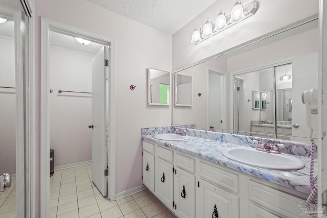 bathroom featuring vanity, tile patterned flooring, and a textured ceiling