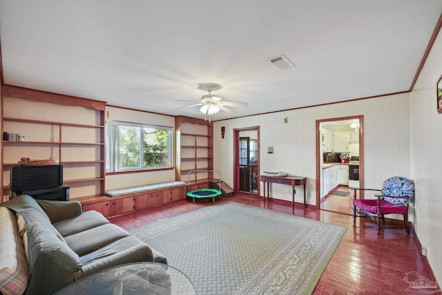 living room with ceiling fan, ornamental molding, and wood-type flooring