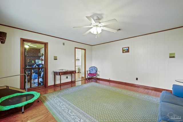 recreation room featuring hardwood / wood-style flooring, crown molding, and ceiling fan