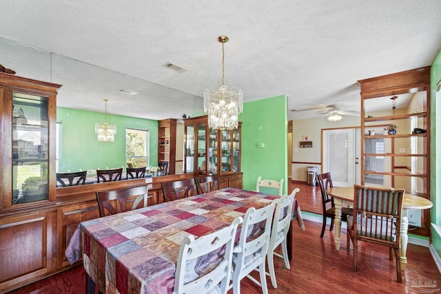 dining area featuring a textured ceiling, dark hardwood / wood-style floors, and a chandelier