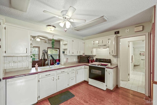 kitchen featuring sink, white cabinetry, light wood-type flooring, white dishwasher, and electric stove