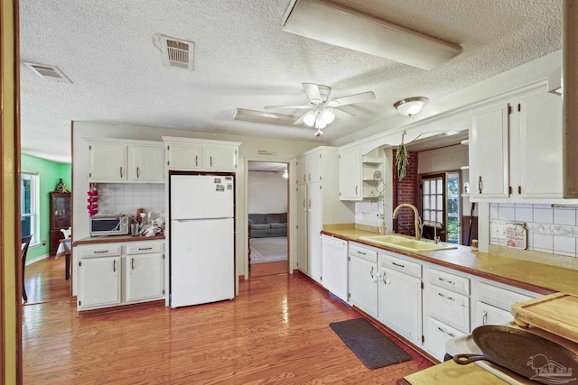 kitchen featuring sink, white appliances, ceiling fan, light hardwood / wood-style floors, and white cabinets