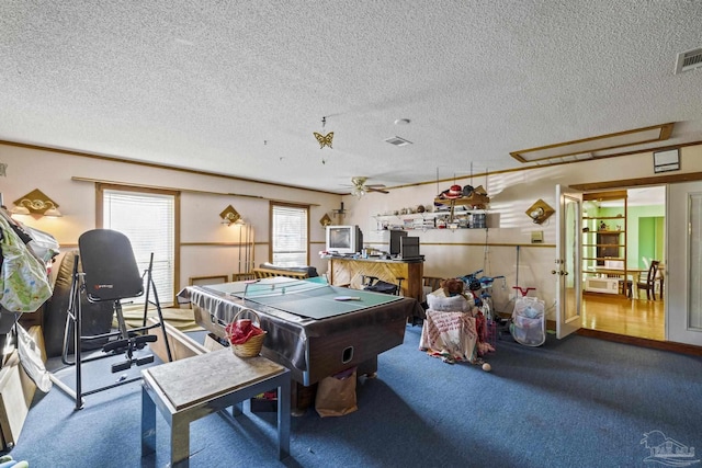 game room with ceiling fan, carpet, and a textured ceiling