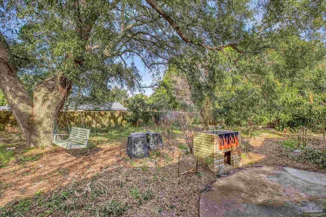 view of yard with an outdoor brick fireplace