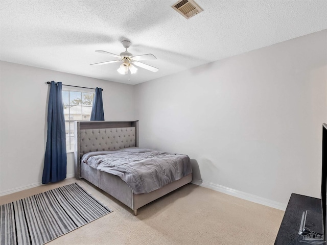 bedroom with visible vents, a textured ceiling, carpet floors, baseboards, and ceiling fan