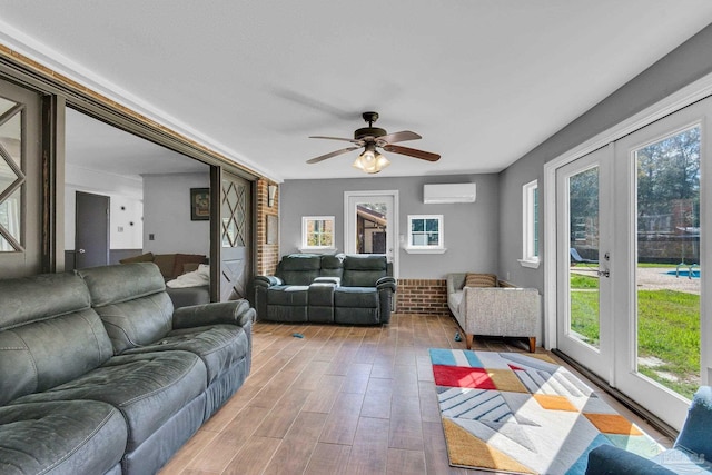 living room featuring ceiling fan, a wall mounted air conditioner, and light wood-style floors