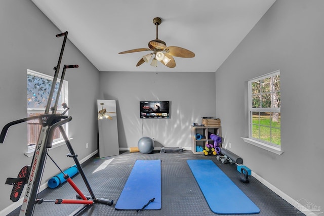 exercise room with baseboards, lofted ceiling, and a ceiling fan