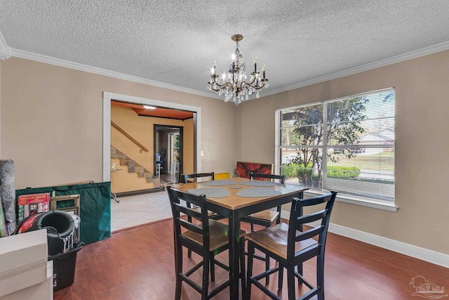 dining room with crown molding, a notable chandelier, and wood finished floors