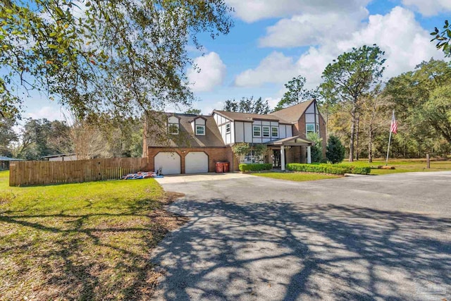 view of front facade featuring brick siding, an attached garage, fence, a front yard, and driveway