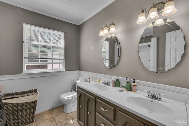 bathroom featuring a sink, toilet, double vanity, and a textured ceiling