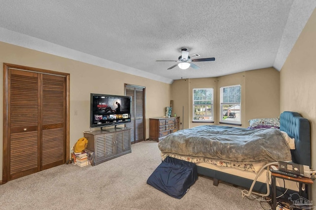 bedroom featuring lofted ceiling, a textured ceiling, ceiling fan, and carpet flooring