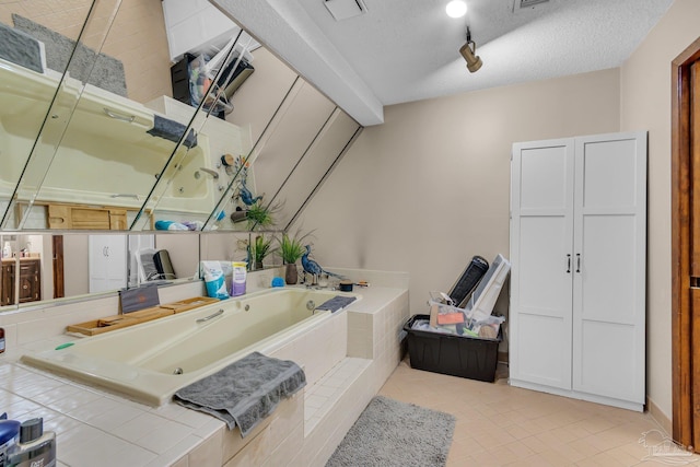 full bath featuring visible vents, rail lighting, a textured ceiling, tile patterned floors, and a bath