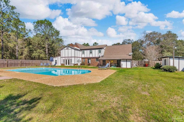 view of pool featuring an outbuilding, a lawn, a fenced in pool, and a fenced backyard