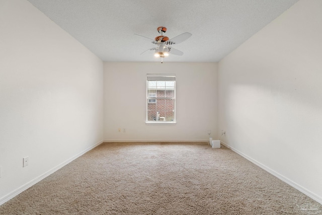 carpeted spare room with ceiling fan and a textured ceiling