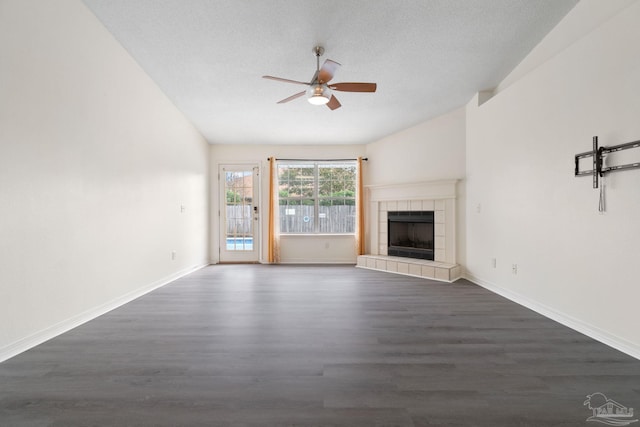 unfurnished living room with ceiling fan, dark hardwood / wood-style floors, a textured ceiling, and a fireplace