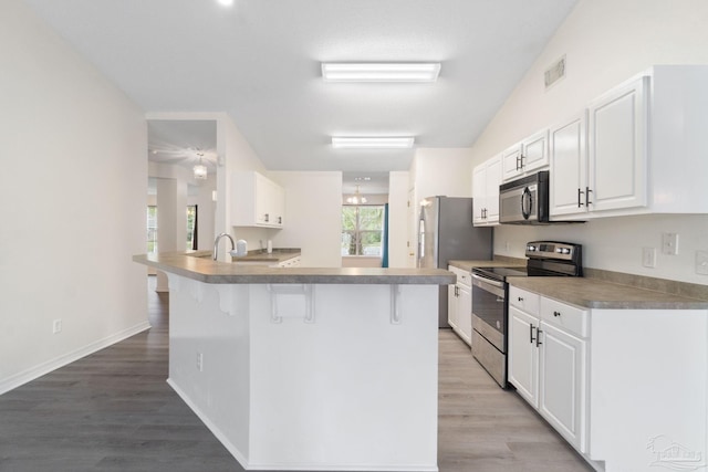 kitchen with stainless steel electric range oven, a breakfast bar area, white cabinets, and light hardwood / wood-style flooring