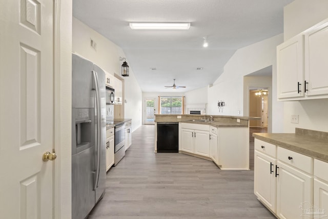 kitchen with appliances with stainless steel finishes, lofted ceiling, sink, white cabinets, and ceiling fan