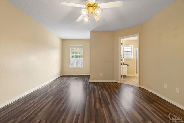 spare room featuring ceiling fan, dark hardwood / wood-style floors, and a textured ceiling