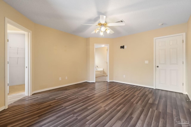 empty room with ceiling fan, dark hardwood / wood-style floors, and a textured ceiling