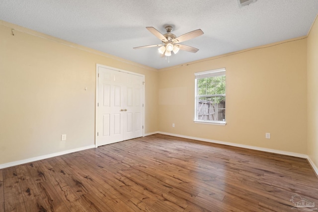 unfurnished room featuring hardwood / wood-style flooring, ceiling fan, ornamental molding, and a textured ceiling