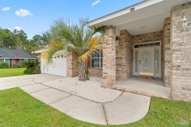 view of exterior entry featuring a garage and a lawn