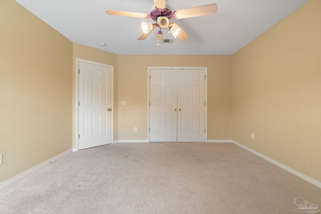 unfurnished bedroom featuring ceiling fan, a closet, carpet, and a textured ceiling