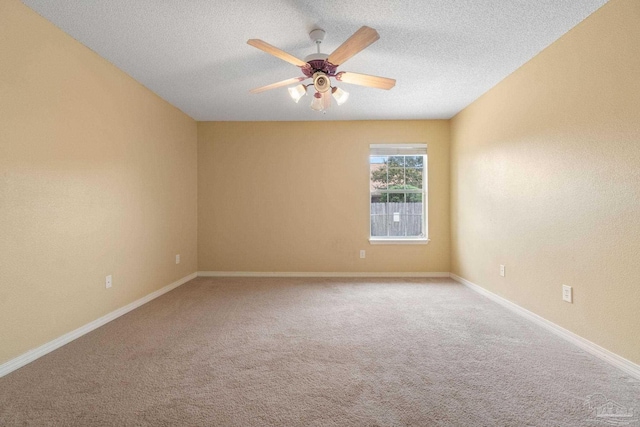 carpeted spare room featuring ceiling fan and a textured ceiling