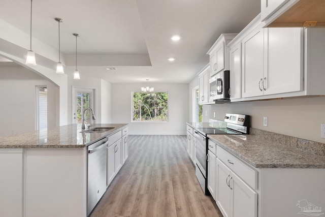 kitchen with a kitchen island with sink, light wood-type flooring, white cabinetry, stainless steel appliances, and sink