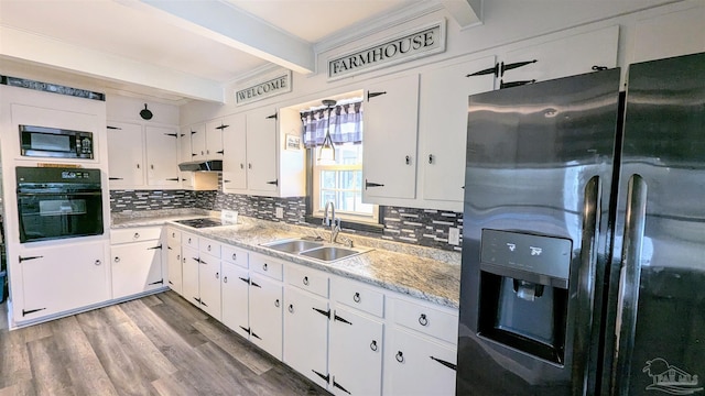 kitchen featuring beam ceiling, a sink, black appliances, light countertops, and under cabinet range hood