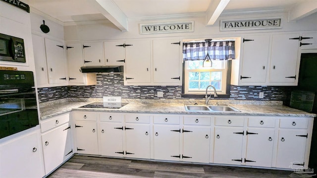 kitchen featuring beam ceiling, black appliances, extractor fan, and a sink