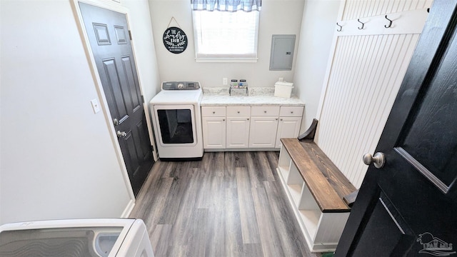 washroom featuring electric panel, cabinet space, washer / clothes dryer, and dark wood-type flooring