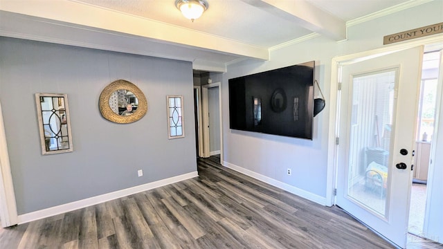 unfurnished living room featuring baseboards, beam ceiling, wood finished floors, and ornamental molding