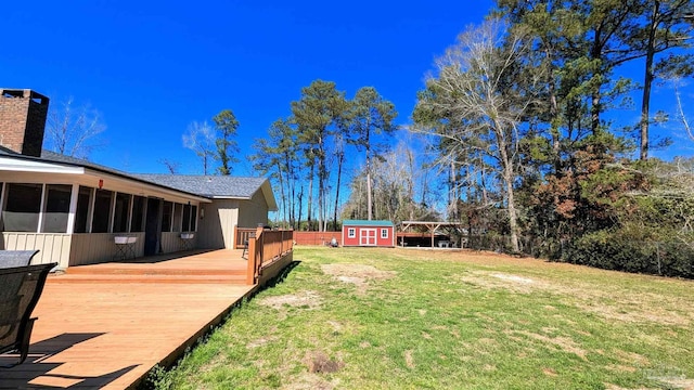 view of yard with a storage unit, an outbuilding, a deck, central AC, and a sunroom