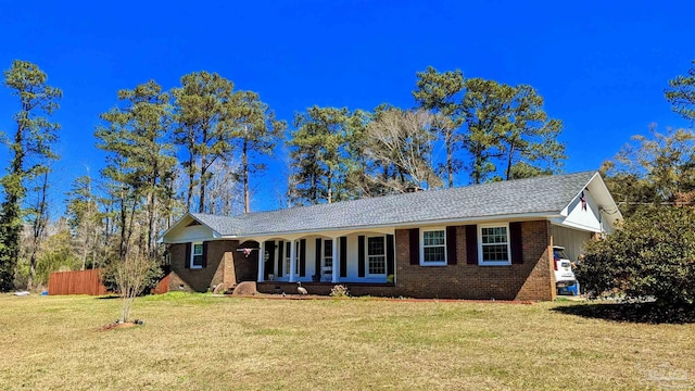 single story home featuring brick siding, fence, a front yard, covered porch, and crawl space