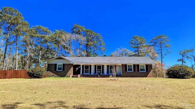 ranch-style home featuring a front yard, fence, brick siding, and crawl space