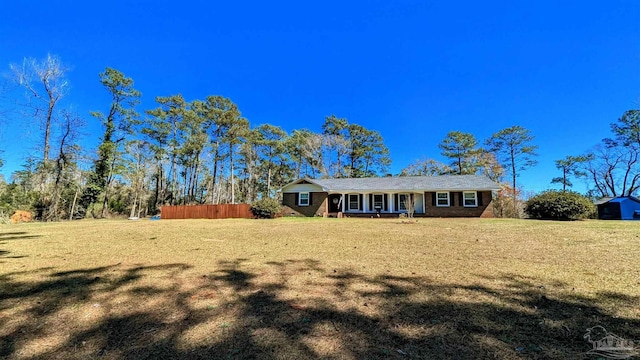 ranch-style home with a front lawn and fence