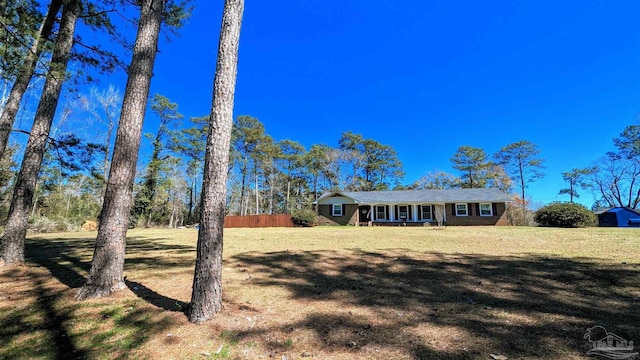 view of front facade featuring a front lawn and fence