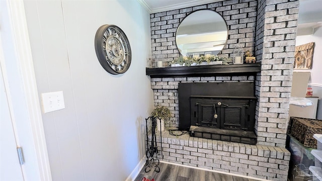 room details featuring a brick fireplace, wood finished floors, and ornamental molding