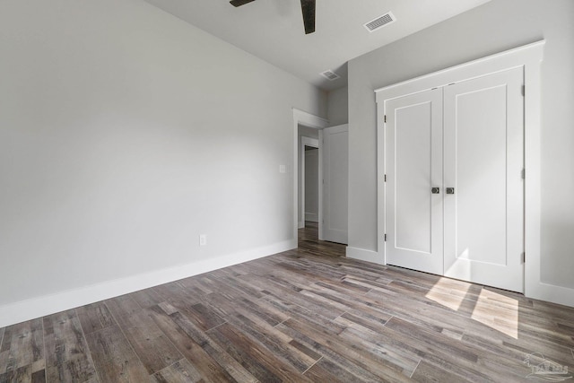 unfurnished bedroom with ceiling fan, a closet, and hardwood / wood-style floors